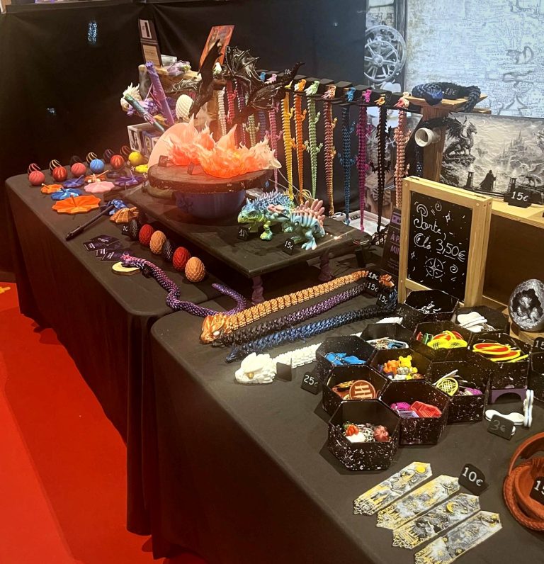 Dragons articulés de toutes les couleurs suspendus sur le stand, à Grimoire et Potions