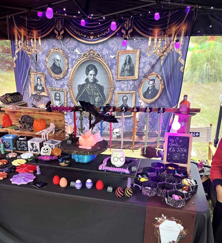 Le stand d’Halloween : portraits gothiques, guirlande violette, dragons, fidgets et porte-clés imprimés en 3D